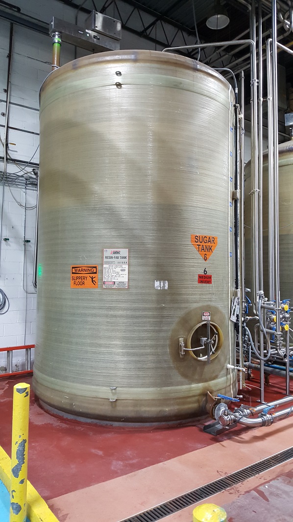 ***SOLD*** used 6,500 gallon FRP (fiberglass) storage tank. Dish top, flat bottom. 9' dia. x 13' T/T.  Built by Viatec Process Storage Systems (Resin-Fab Tank). Previously used in sanitary food and beverage plant as sugar holding tank. Side manway 20